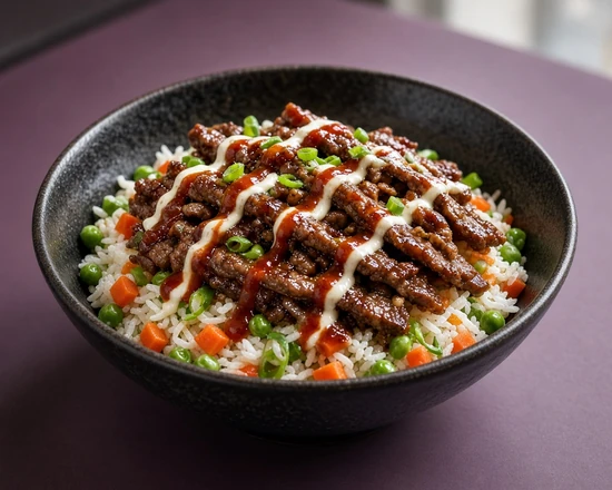 Sliced Korean beef rice bowl with peas, carrots and sauce drizzles